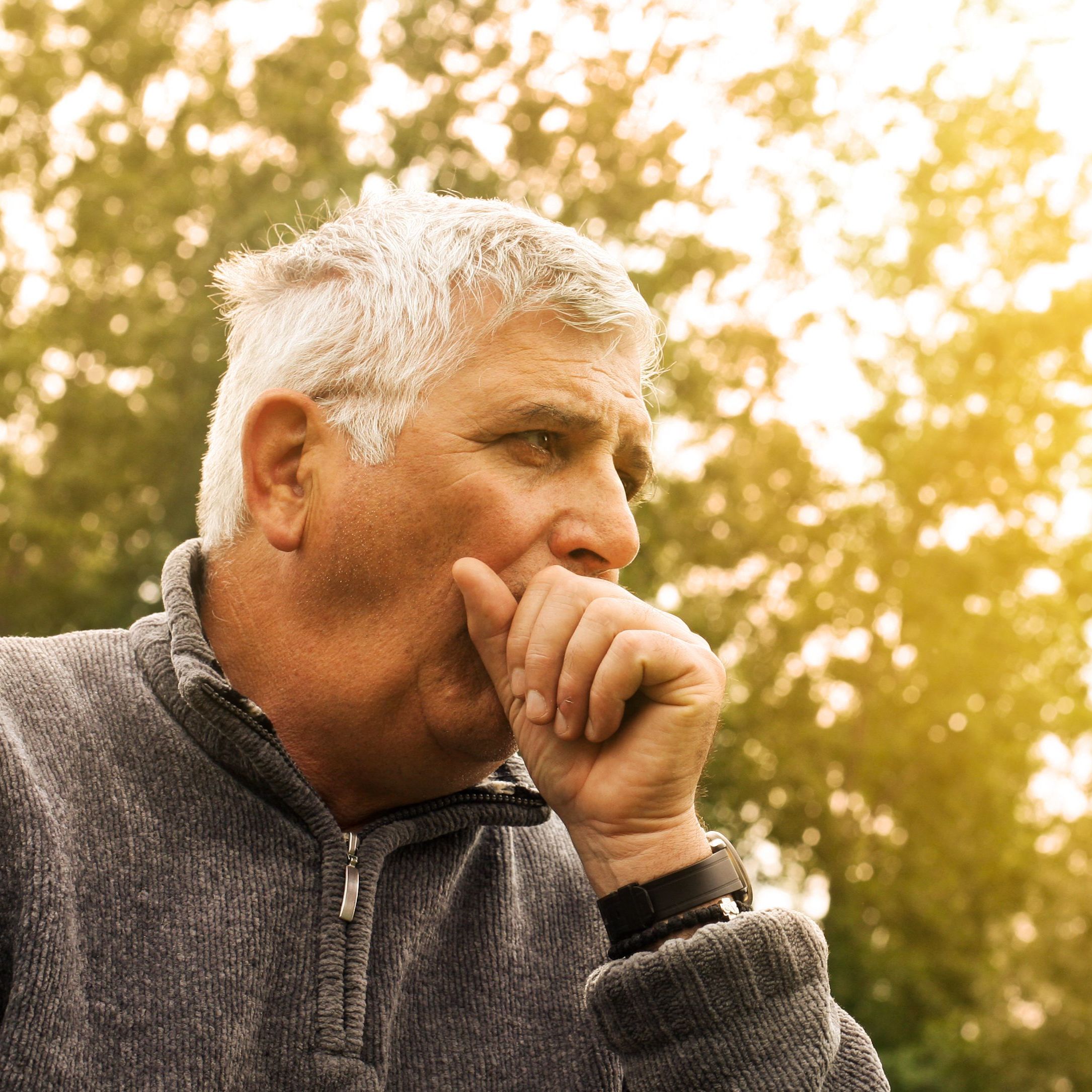 man with allergies coughing outside